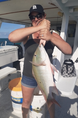A photo of Kathy holding a fish she caught.