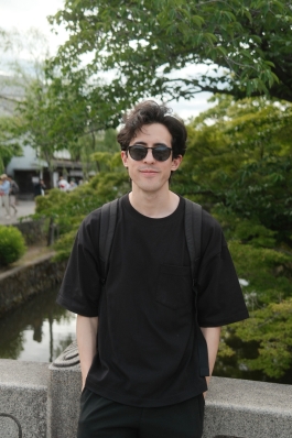 A photo of James next to a tree. 