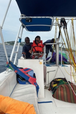 A photo of Jennifer steering a boat. 