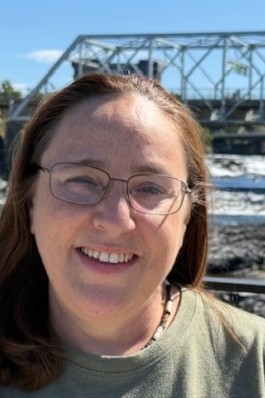 A photo of Lori, with a bridge resting behind her. 