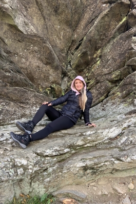 A photo of Jada leaning on a rocky hill. 