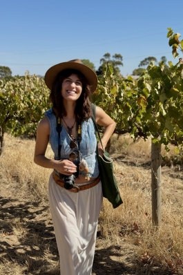 A photo of Kylie near a vineyard. 