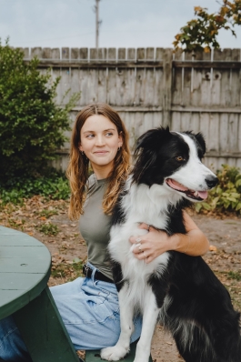 A photo of Taylor and a dog sitting on a bench. 