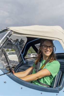 A photo of Taylor in an antique car. 