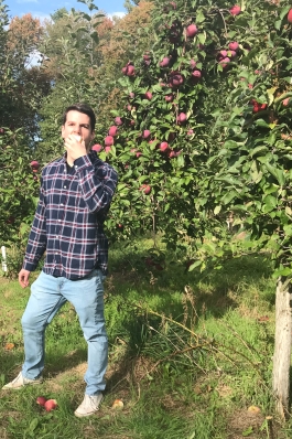 A photo of Michael in an orchard. 
