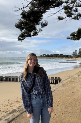 A photo of Emily on the shore of a Melbourne beach. 