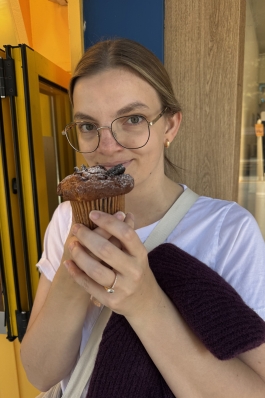 A photo of Emily eating a muffin. 