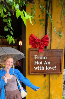 A photo of Lex next to a sign in Vietnam. 