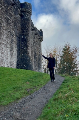 Meg posing next to an ancient castle. 