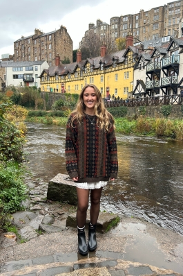 Meg posing next to distinctive homes. 