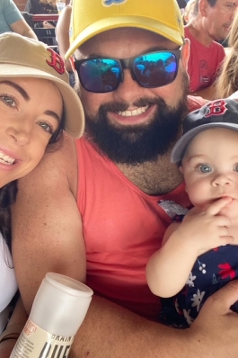 Chelsea, her husband and her daughter smiling at the camera. 