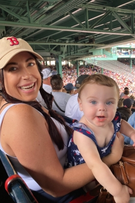 Chelsea and her daughter smiling at a baseball game. 