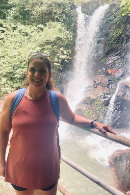A photo of Whitney with a waterfall behind her. 