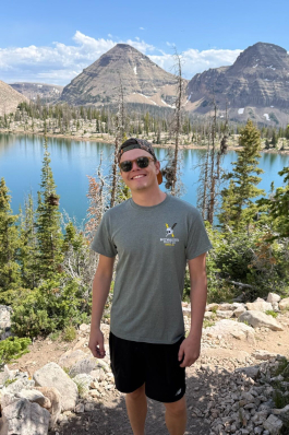 August smiling with a mountainous backdrop. 