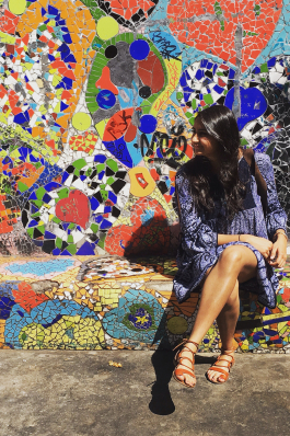 Amee sits in front of a mural in Chile. 