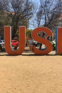 Kori posing behind words in Curacao. 