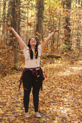 Kori throwing leaves into the air. 