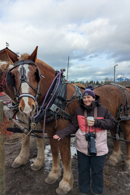 Kim taking a photo with a horse in Banff. 