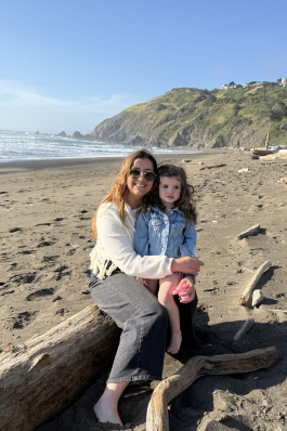 A photo of Jessica and a child on the beach in California. 