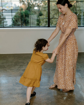 Aimee Kohler and child holding hands dancing
