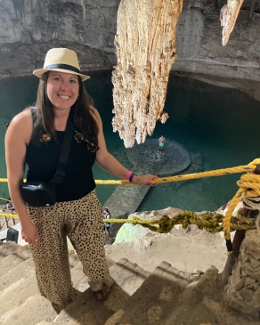 AllyDrees in a cenote, standing next to a very large stalactite
