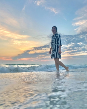 Amanda Pfeil wading in the surf near sunset