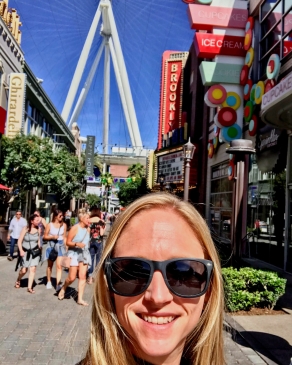 Amanda Steward on a boulevard full of bright colored buildings and shoppers