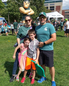 Amy Bibbings and family wearing Michigan State colors outside a stadium