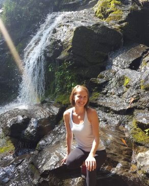 Amy Overbay seated in front of a waterfall