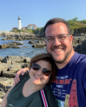 Andrea Ticola in front of lighthouse on a rocky shore