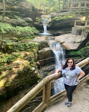 Andraya Ticola stands by railing of a waterfall overlook
