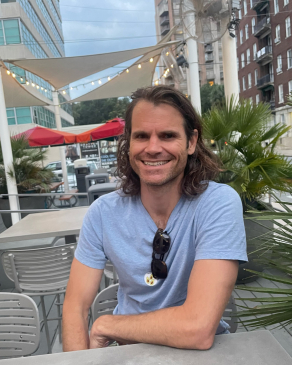 Andy Roberts sitting at a table at a sidewalk cafe