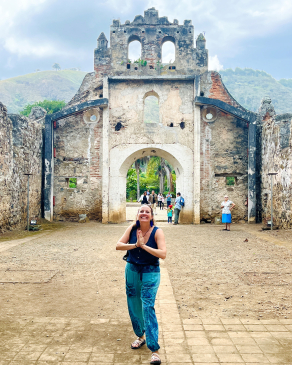 Carly Stedman Norosky in front of a historic Spanish-style gate in Costa Rica