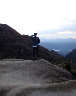 Carson Young looking out in the Andes mountains of Peru from an erosion-worn rock formation