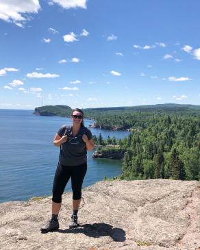 Chelsea Mikesell on a rock ledge in front of a lake