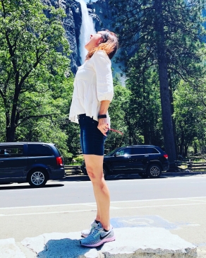 Demetria Clemons in front of a roadside waterfall in Yosemite