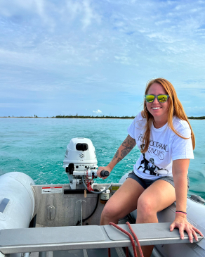 Meghan Alden drives the tiller on a dinghy in the Bahamas