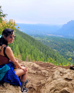 Stacey D'Andelet sits looking out at the wooded distance over a cliff near Rattlesnake Lake, Seattle