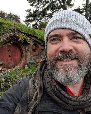 CA clark in front of the hobbit homes in NZ