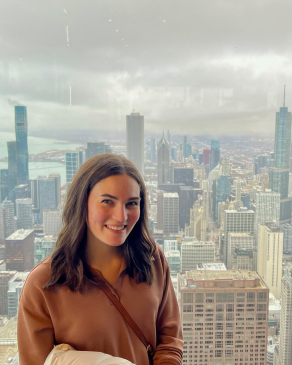 woman high up in a building in front of a city scape