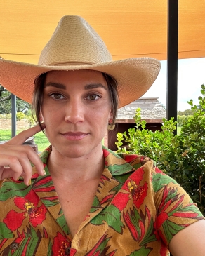 Laura Mier on a cowboy hat and shirt with red flowers