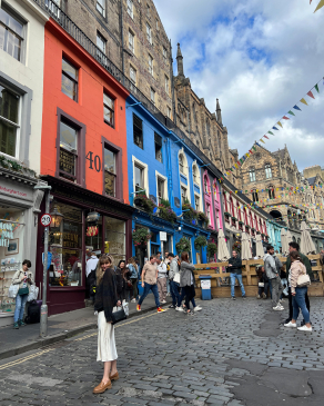 Andrea Valentini standing in front of colorful buildings in Scotland