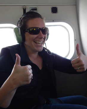 Karin Mast giving the thumbs up on an airplane