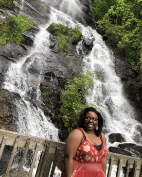 A photo of Melanie with a waterfall in the background