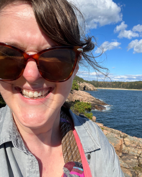 A photo of Katie with a lake back drop