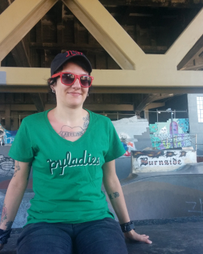 A photo of Lori sitting outside a skate park.