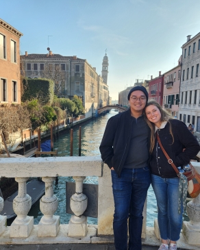 A photo of Holly and her husband on a bridge over a river. 