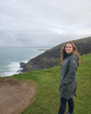 A photo of Holly near a cliff overlooking an ocean