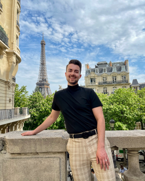 A photo of Joe in Paris with the Eifel tower in the background.