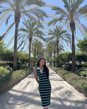 A photo of Tenzin surrounded by palm trees in Spain.